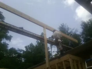 Carpenter setting a ridge beam over a new addition frame — Ice Dam Removal by Roofing Brothers in Chinquapin