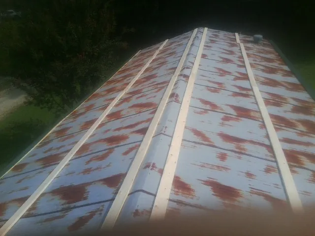 Rusted metal roof panels with new wood purlins before replacement — Storm Damage Roof Repair in Chinquapin by Roofing Brothers