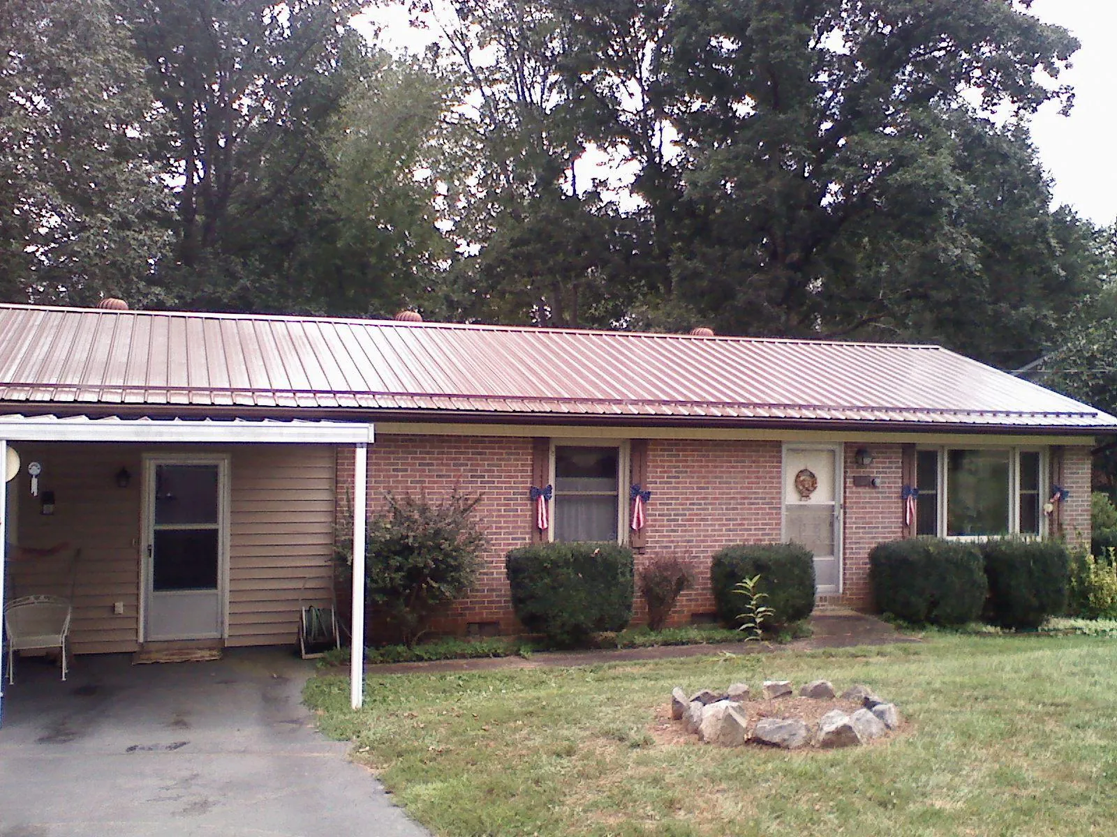 Bronze metal roof and carport on a brick ranch home — Roof Repair work by our crew in Chinquapin