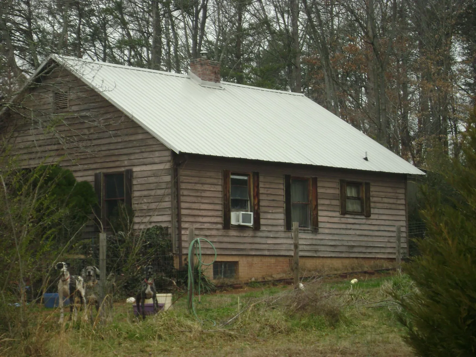 White metal roof on an old wood sided farmhouse, from a Metal Roof Installation job in Chinquapin